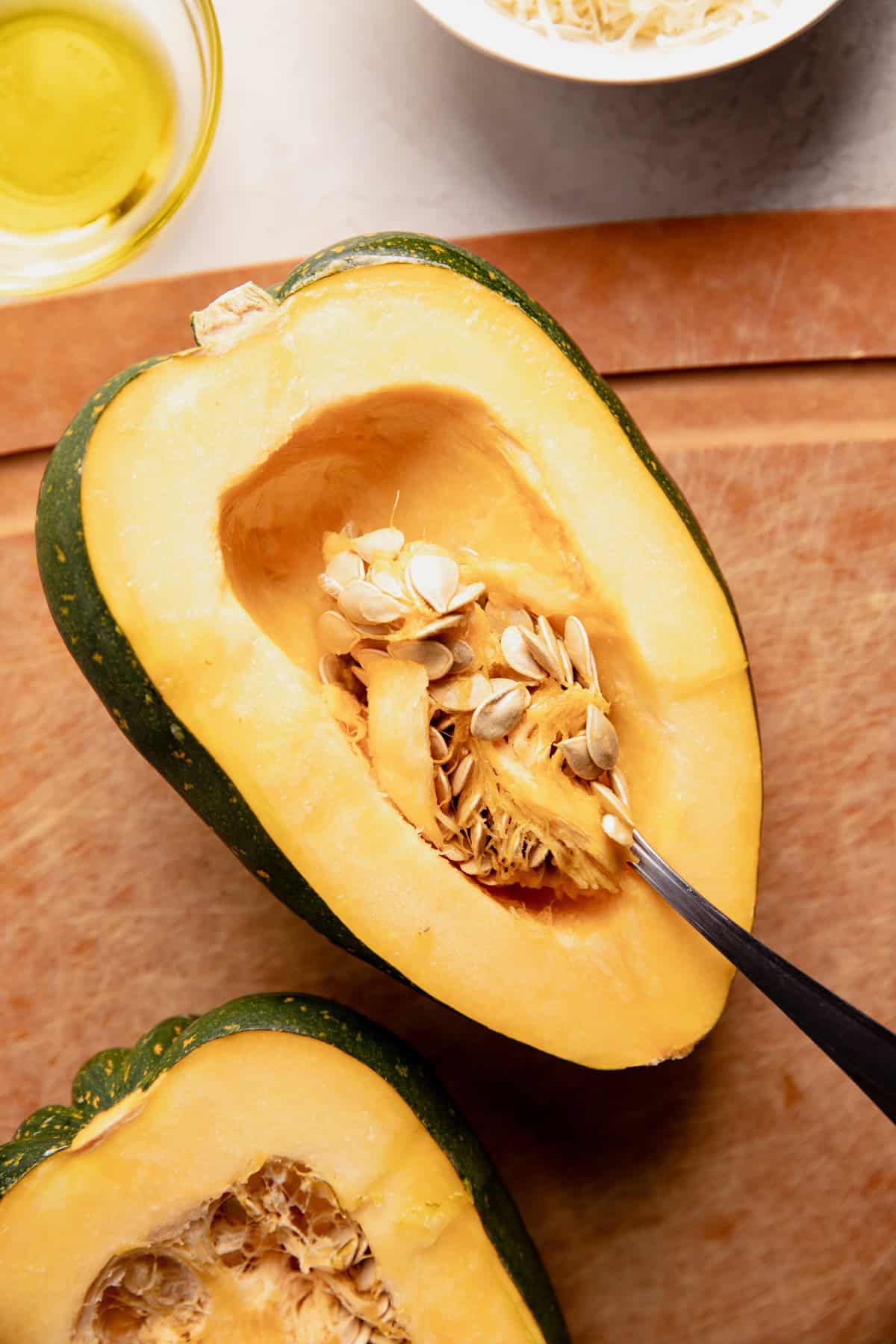 Scooping out the seeds from the center of the acorn squash.