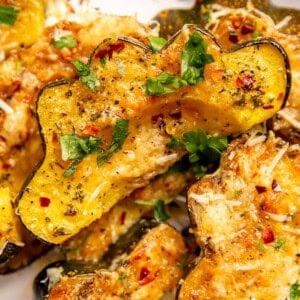 Garlic Parmesan Roasted Acorn Squash served on a plate and garnished with parsley.