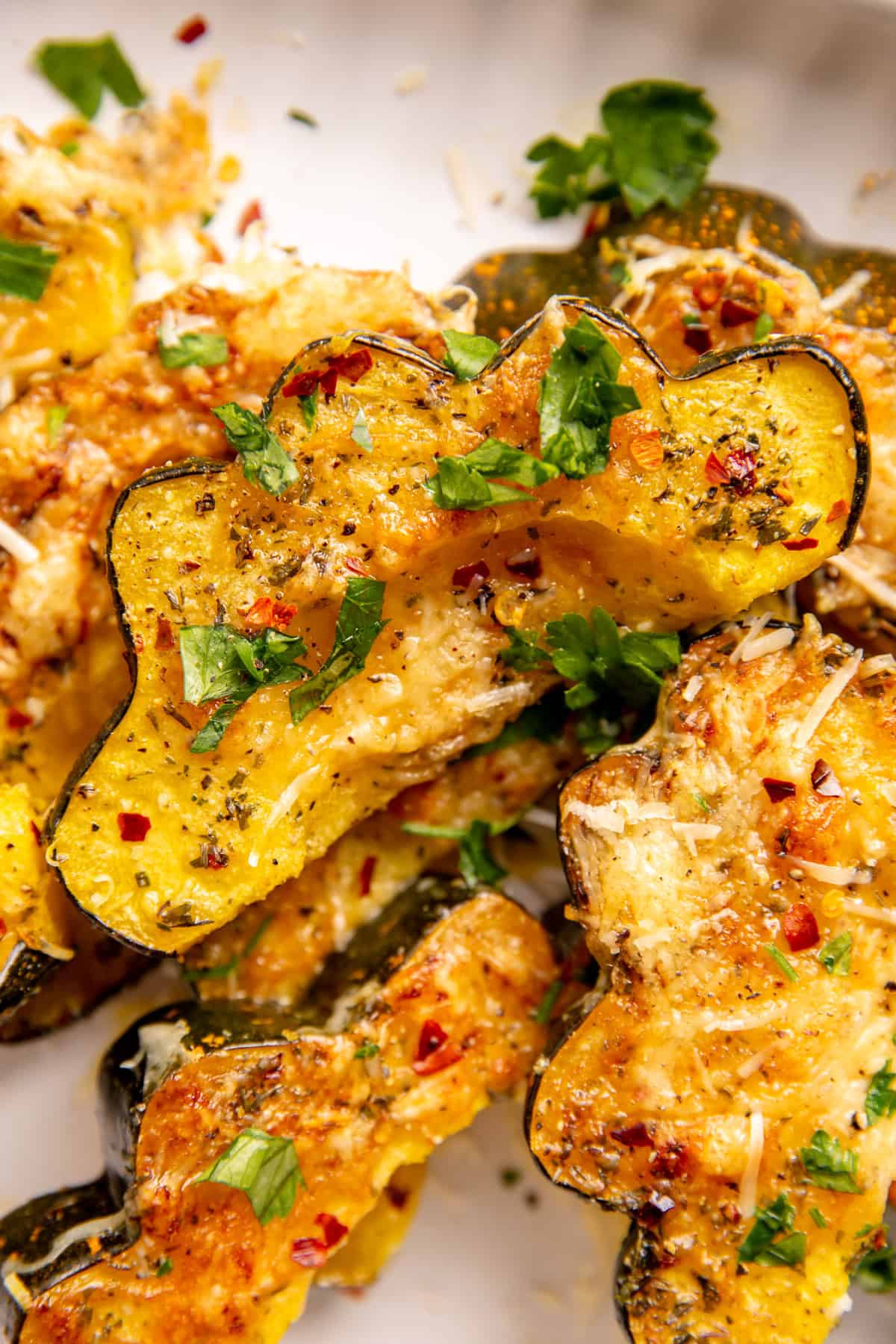 Garlic Parmesan Roasted Acorn Squash served on a plate and garnished with parsley.
