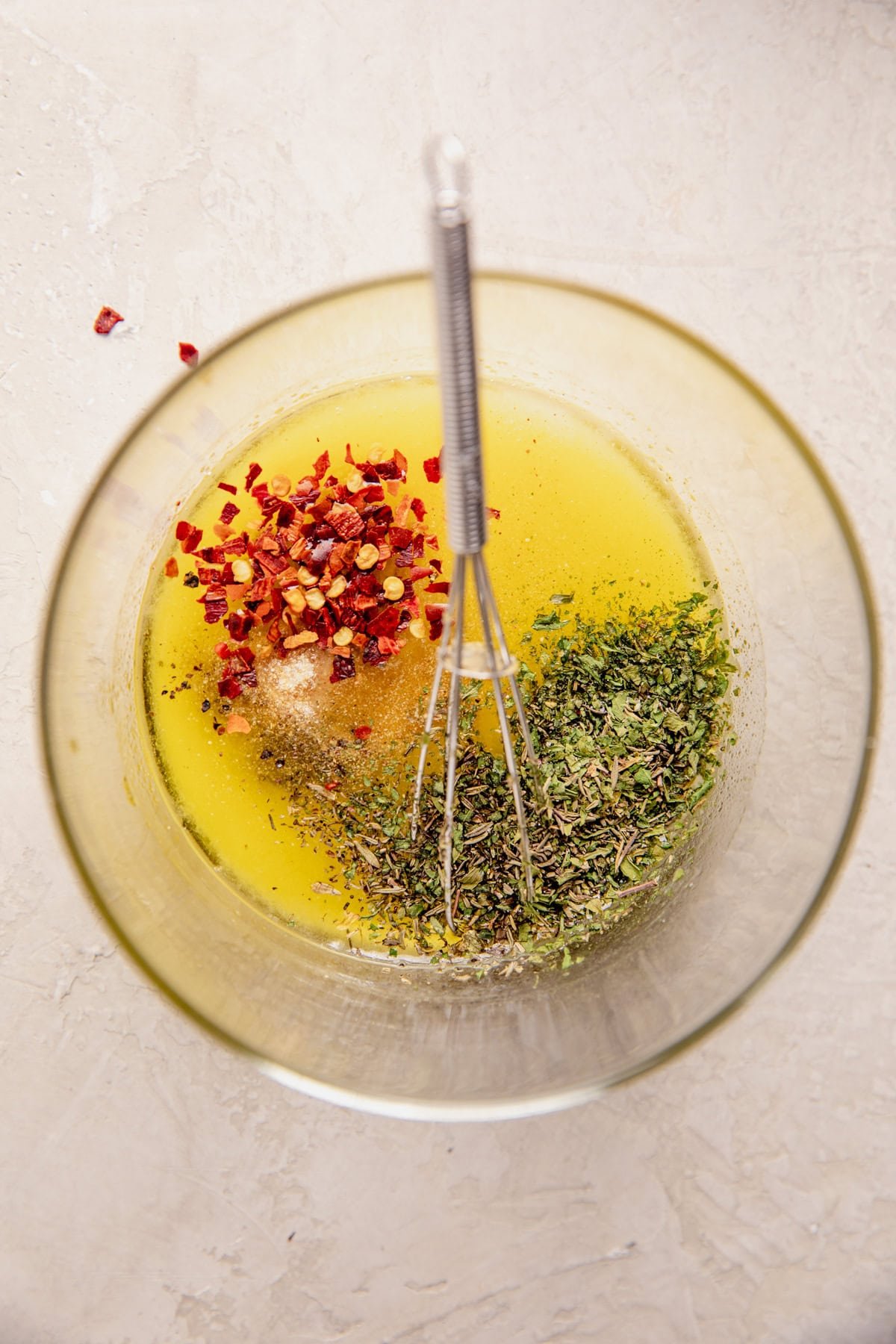 Melted butter, oil, and seasonings in a bowl. 