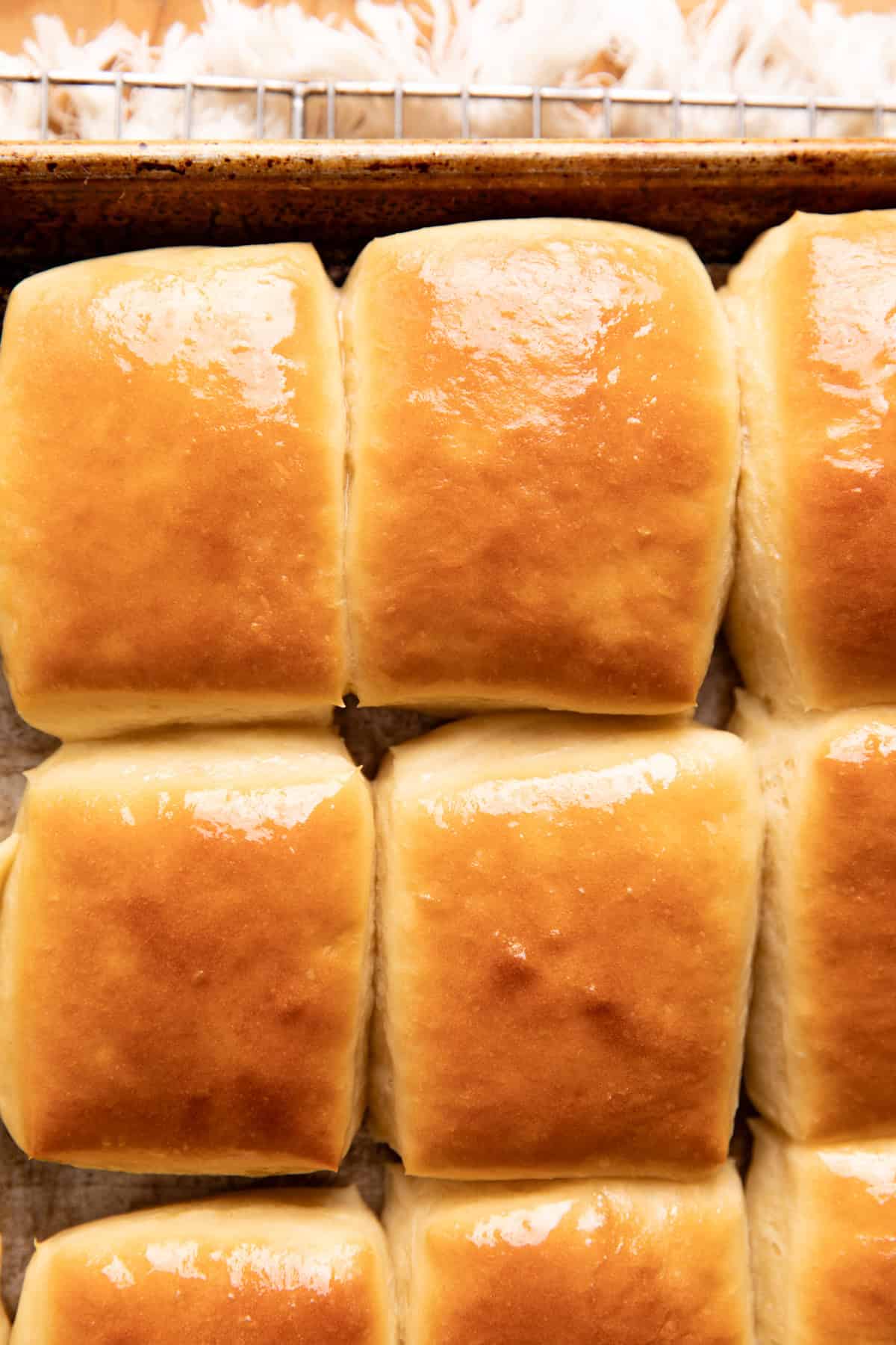 Baked roadhouse rolls on a baking sheet.