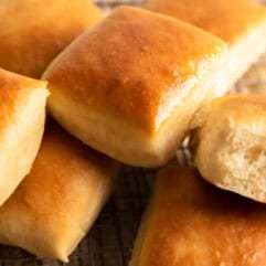 Texas Roadhouse Rolls stacked on a wire rack.