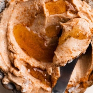 Bowl of whipped cinnamon honey butter with a knife for spreading.