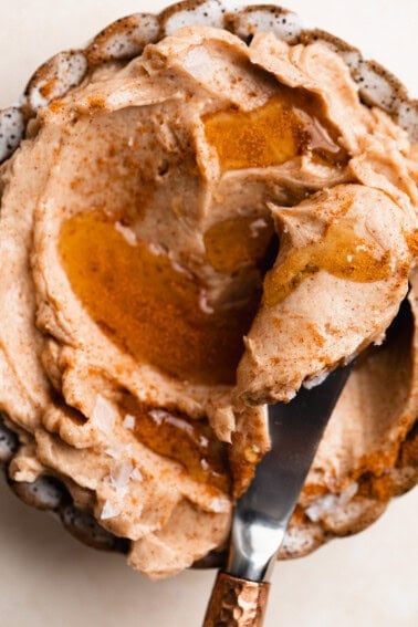 Bowl of whipped cinnamon honey butter with a knife for spreading.