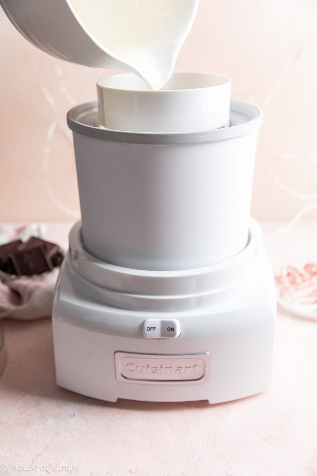 Pouring ice cream mixture into a ice cream maker bowl.