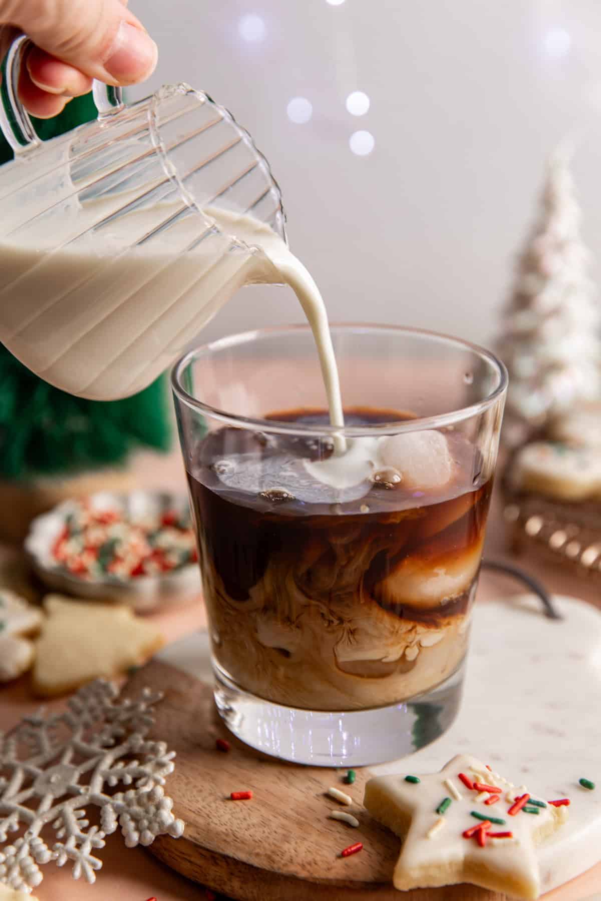 Pouring milk into a glass of chilled espresso to make an iced latte.