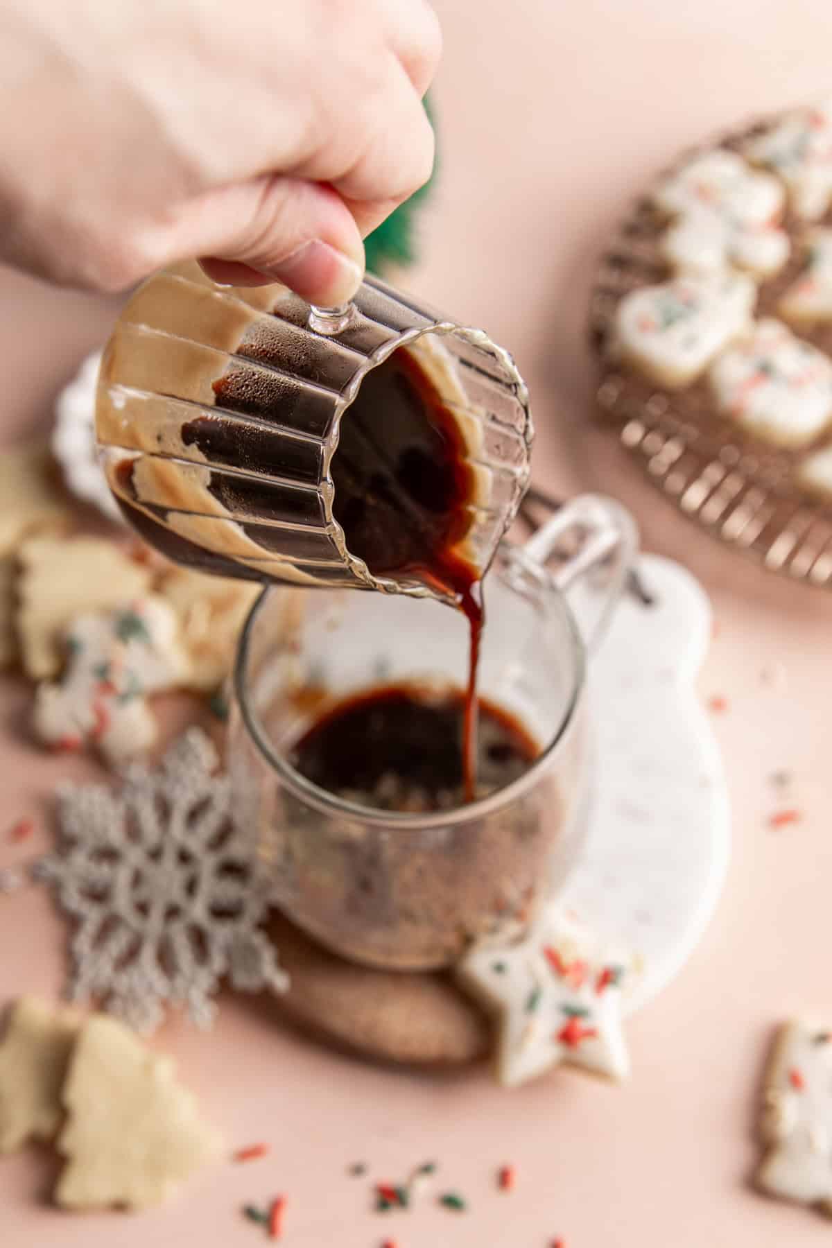Pouring espresso into a glass mug.