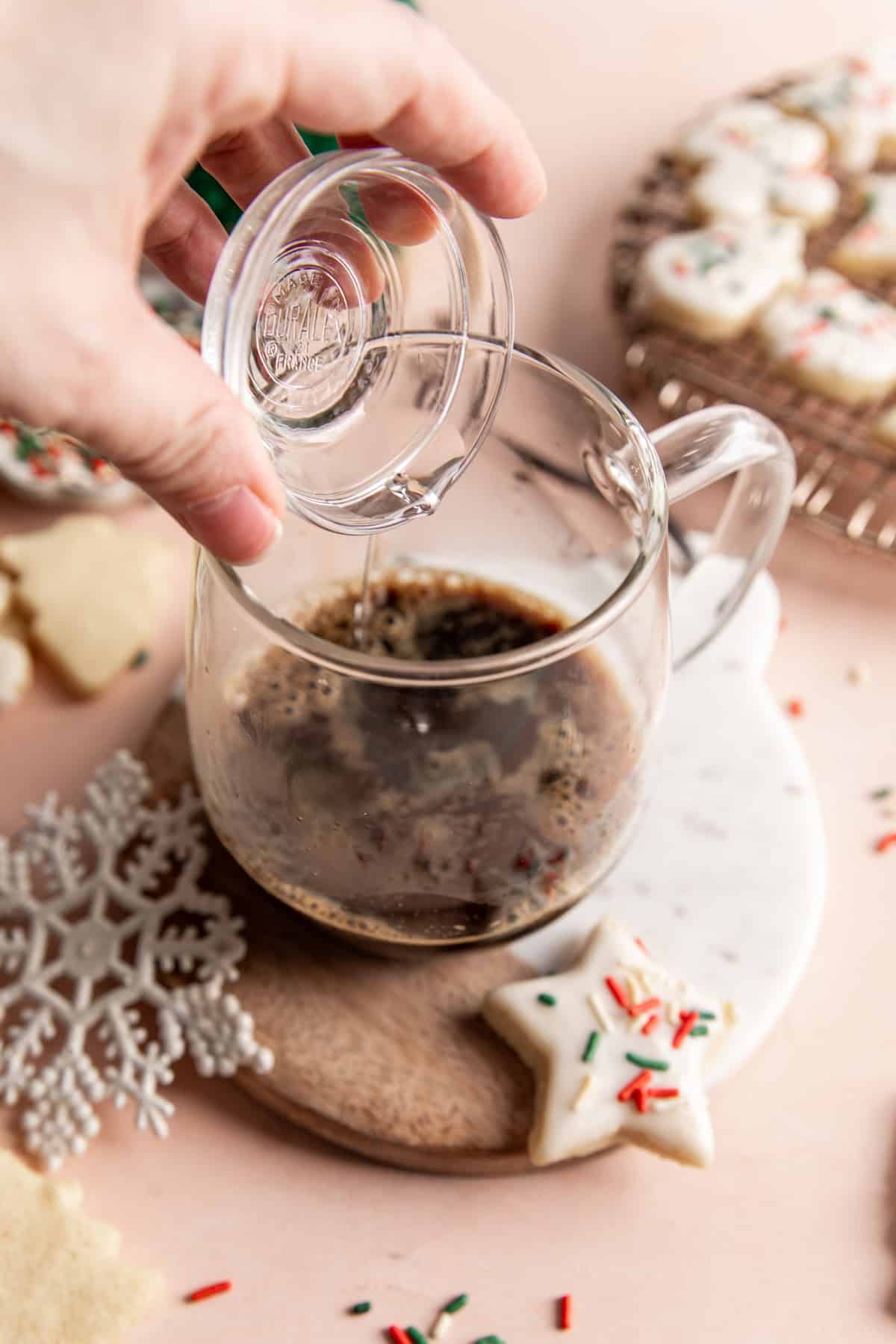 Adding flavor extract to a mug of espresso to make a latte.
