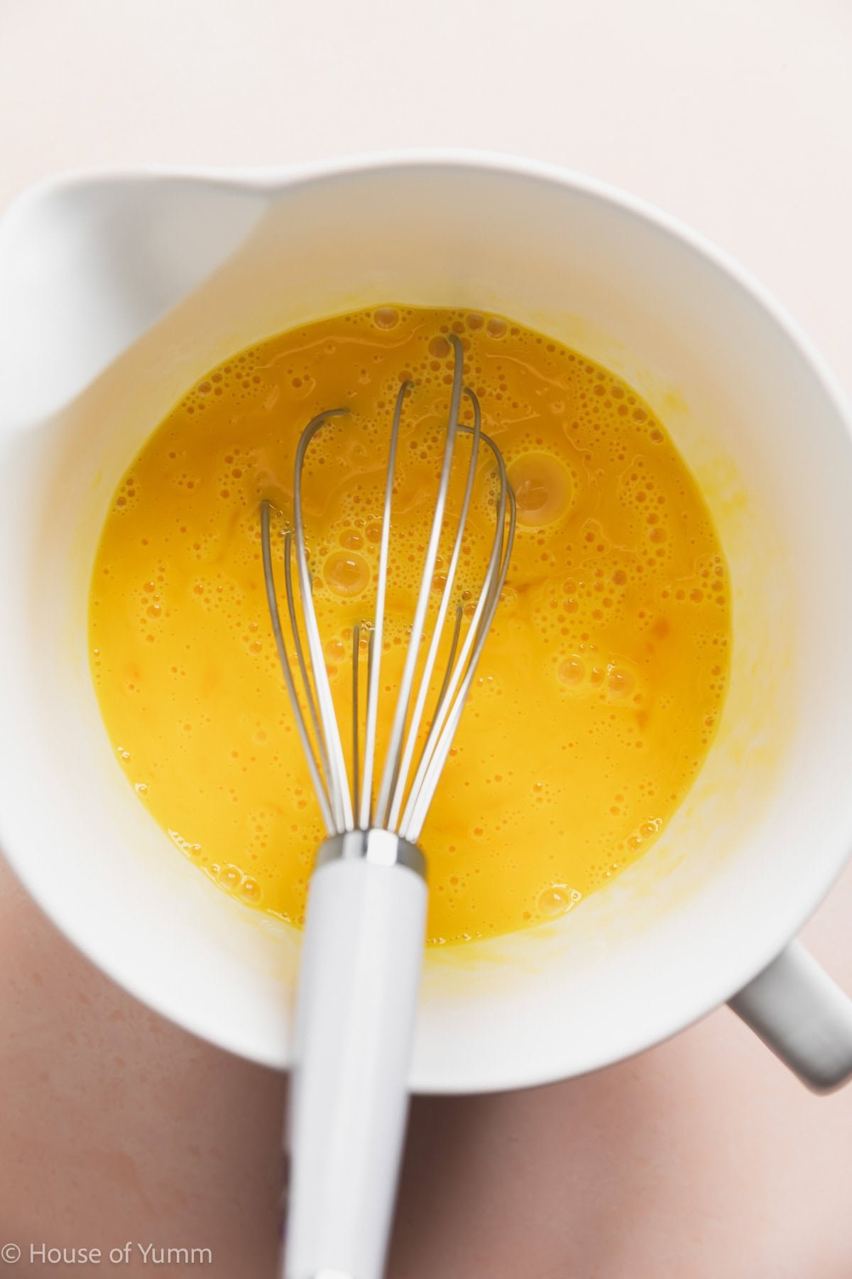 Whisked eggs in a large measuring cup.