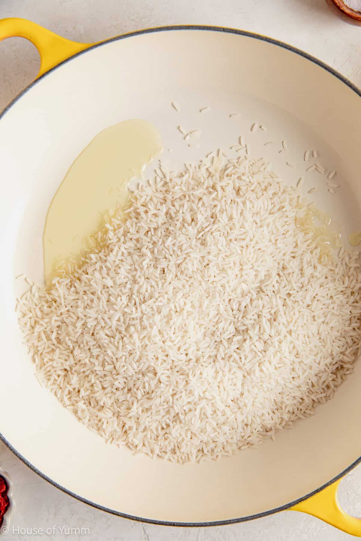 White rice added to a skillet with oil.
