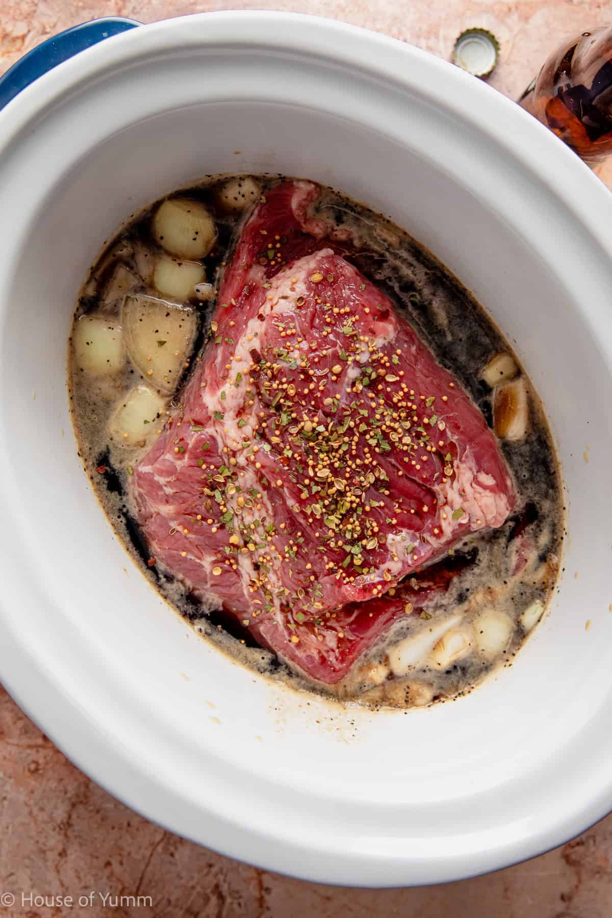 corned beef added to a slow cooker with seasonings, broth, and guiness beer.