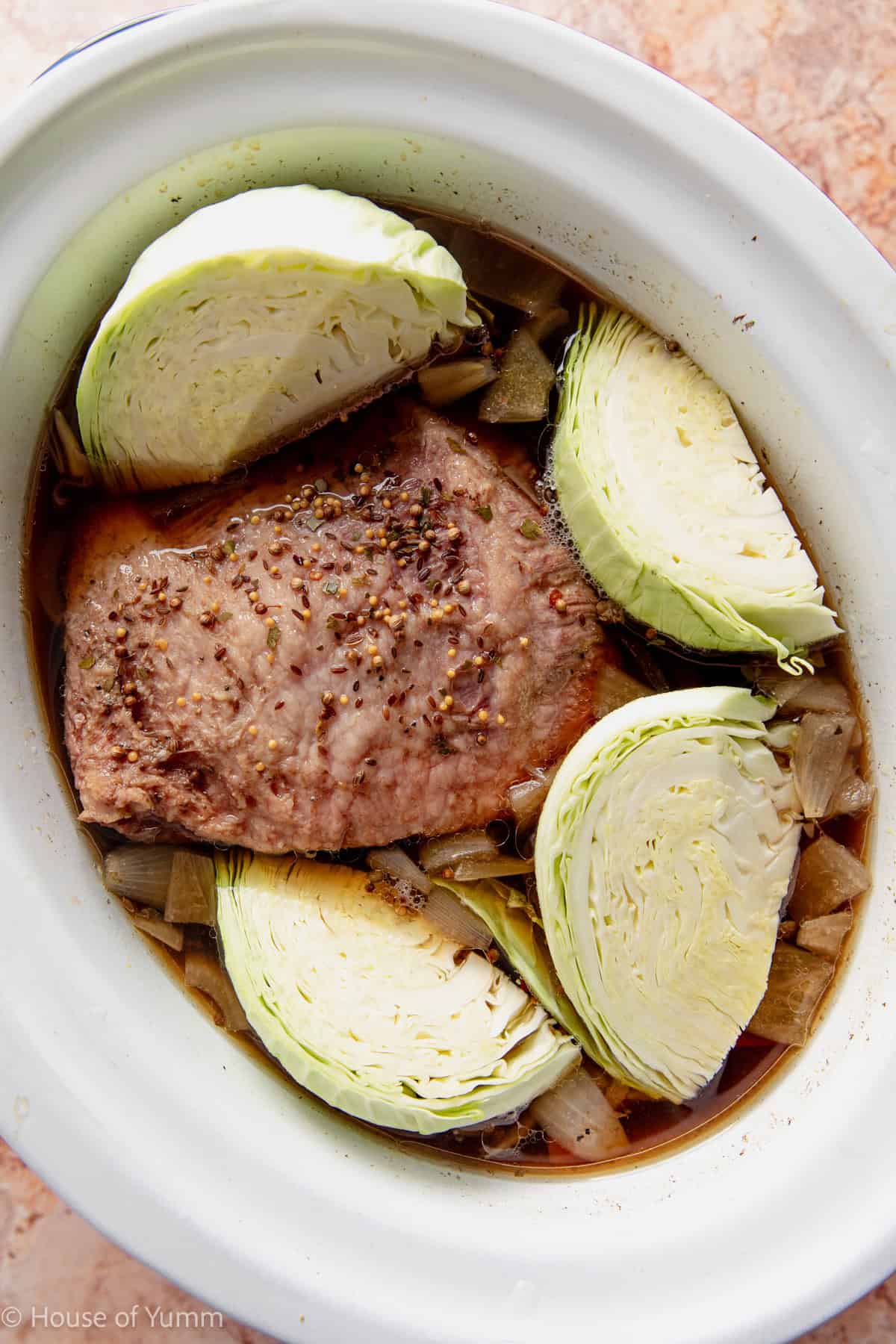 Cabbage added to a corned beef cooking in a slow cooker.