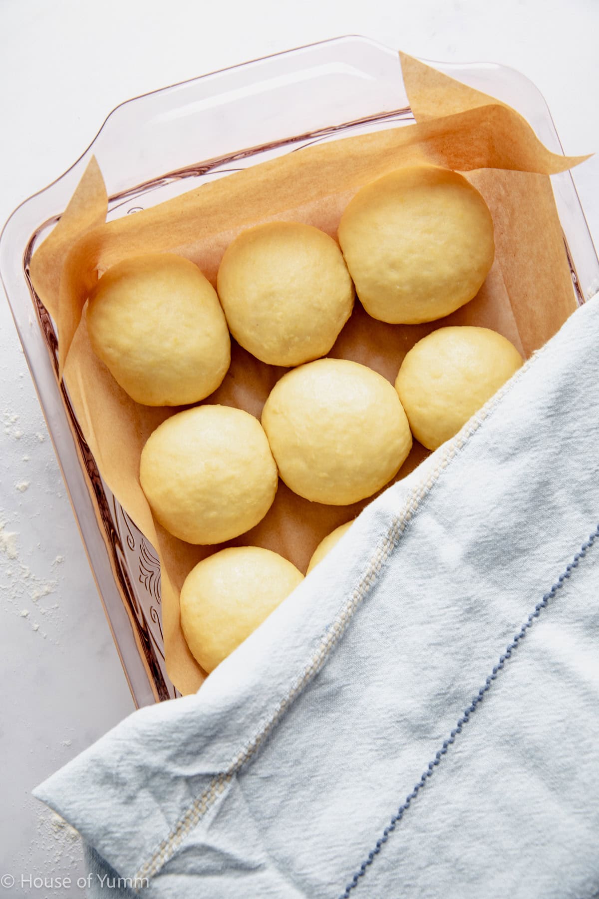 Kolache dough in a prepared baking dish being covered to rise.