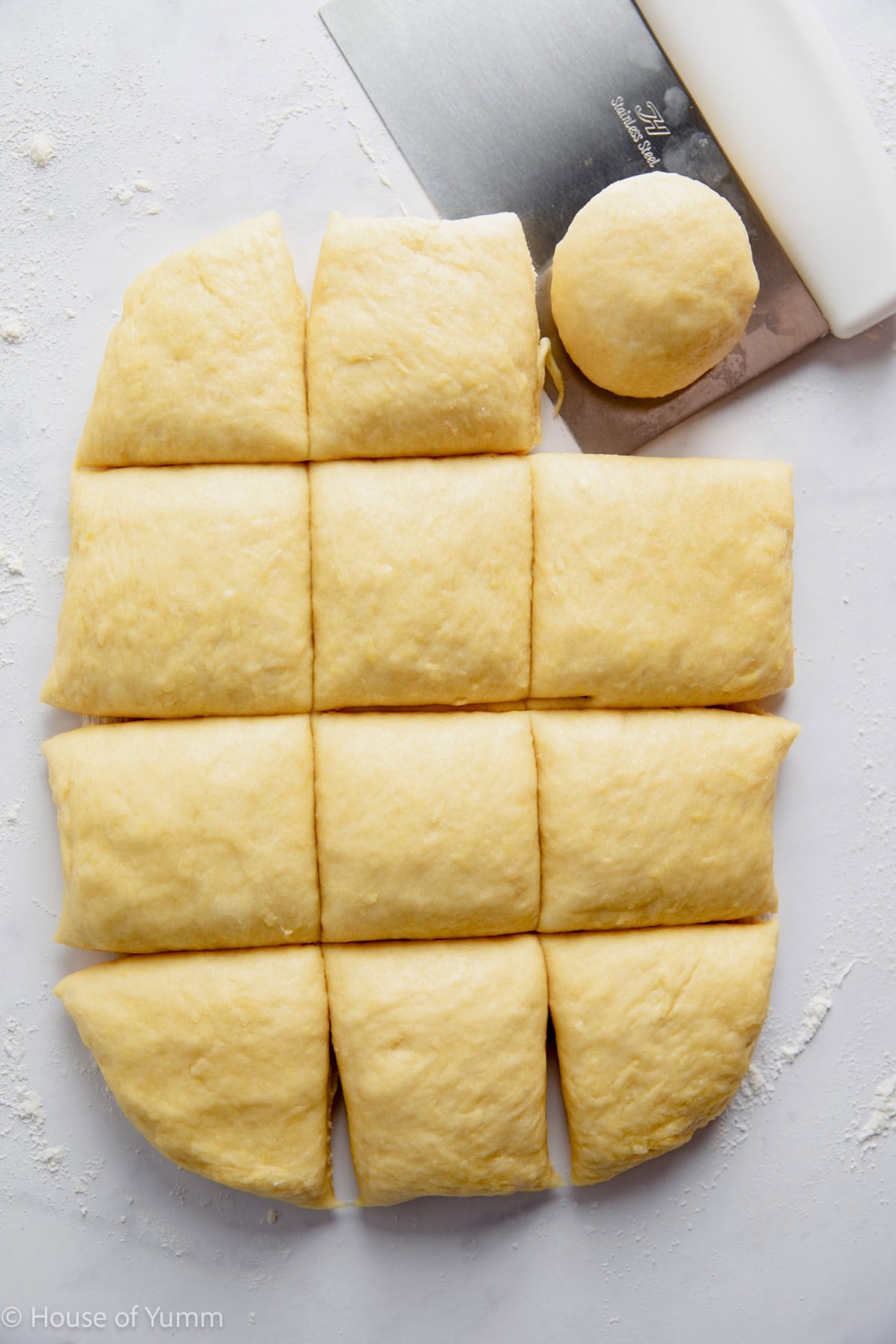 Kolache dough being divided into 12 equal portions and shaped into balls.